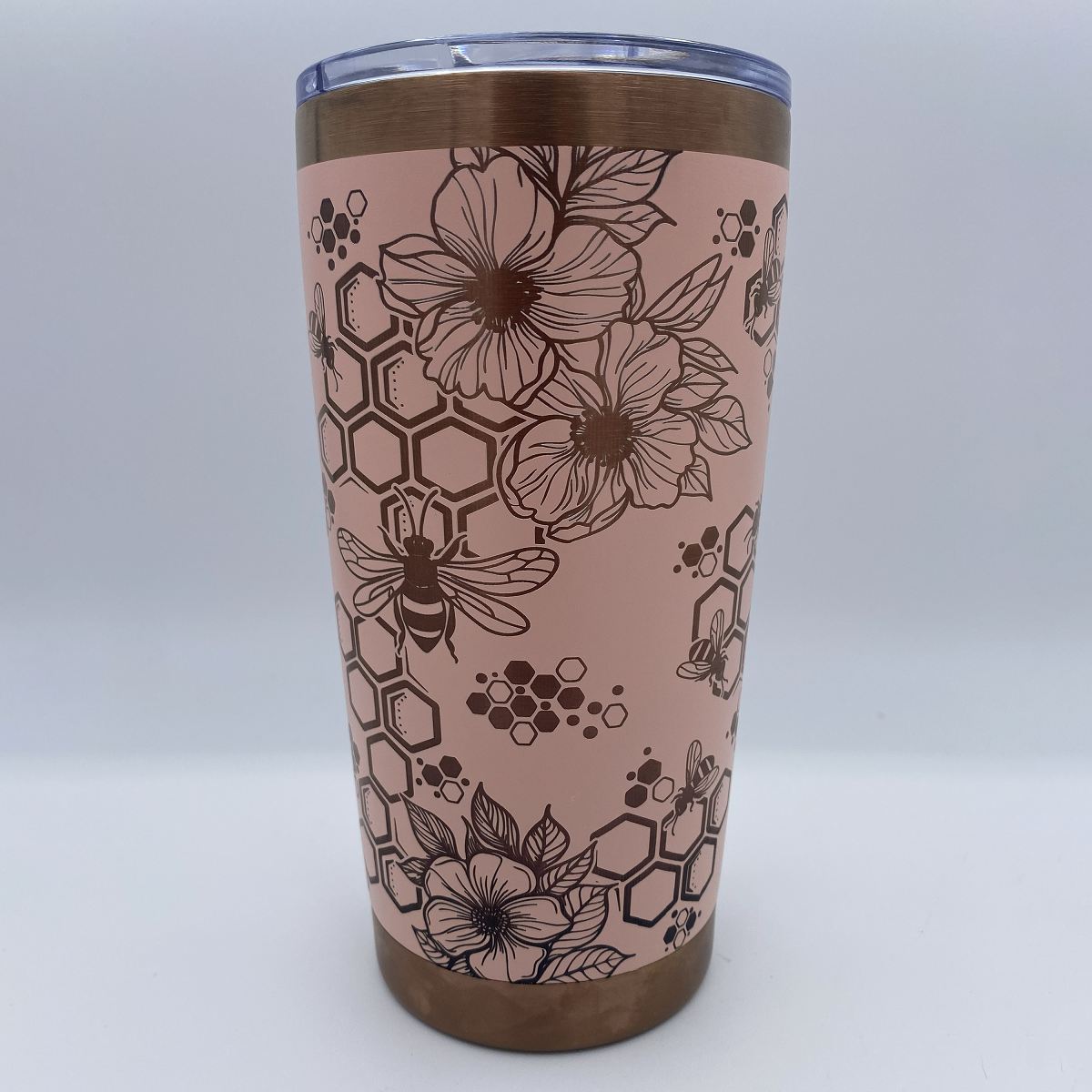 Close-up of bees, honeycomb, and flowers laser engraved on tumbler