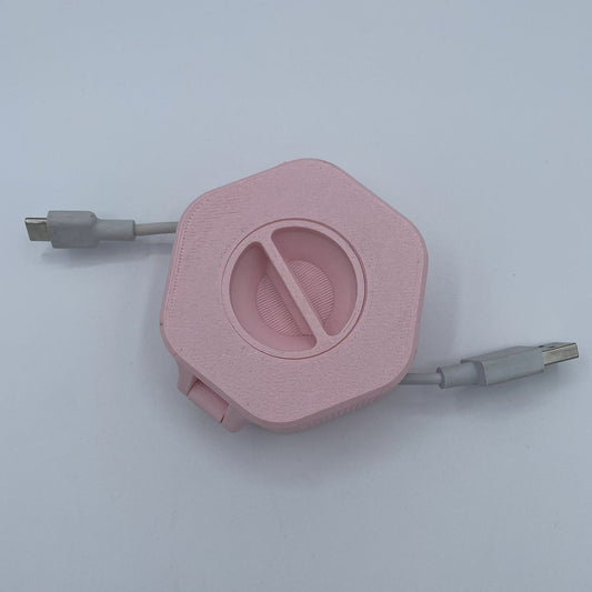 Pink retractable cable with USB connectors on a light gray background