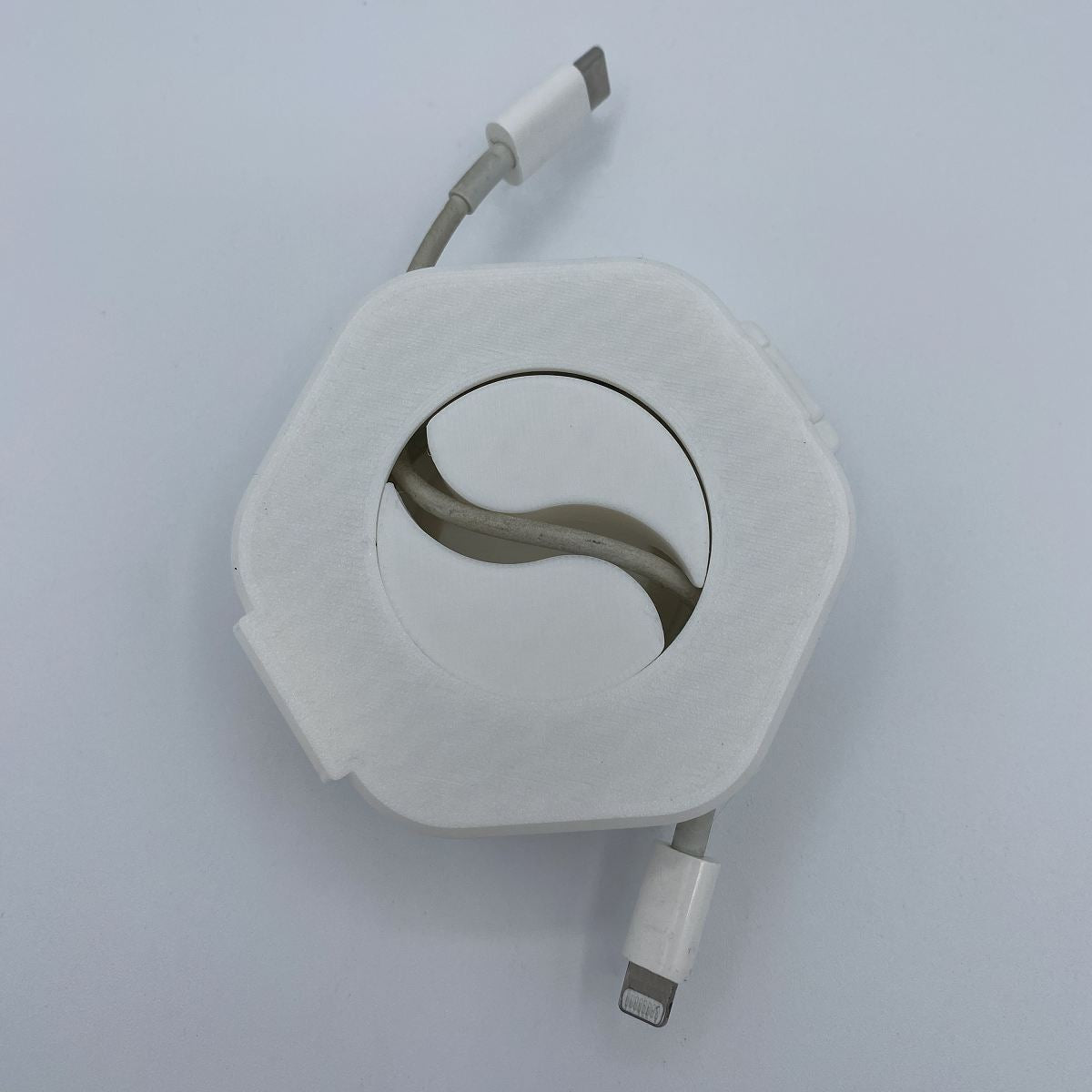 Retractable cable with white casing on a light gray background