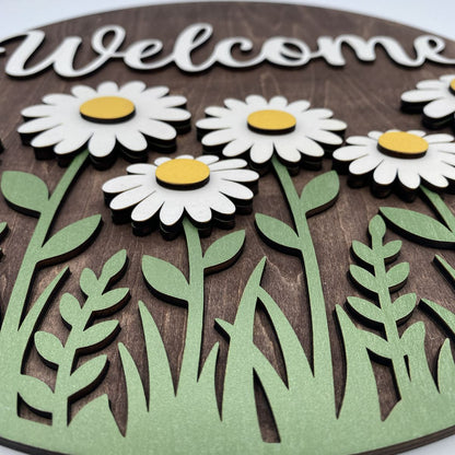 Close-up of layered daisies on the Welcome door sign